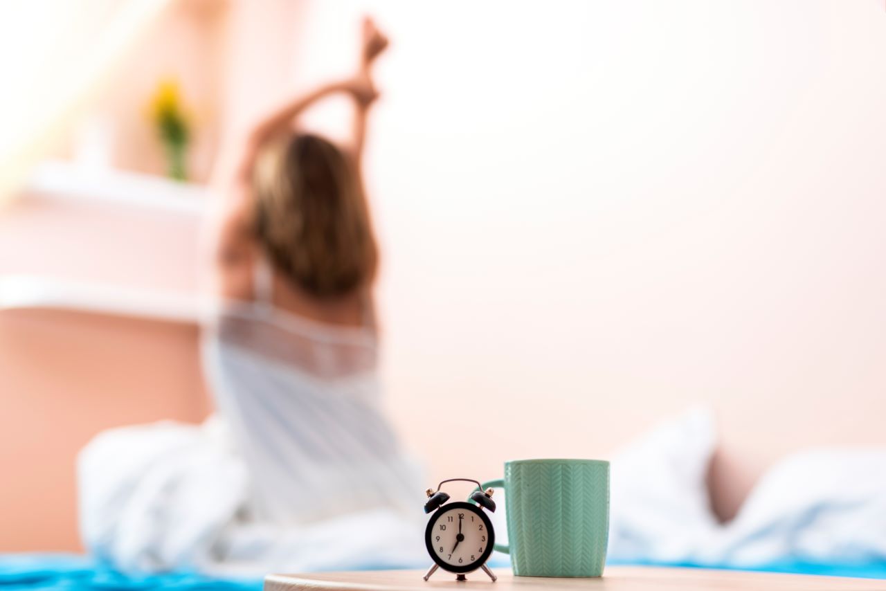 close-up-cup-clock-with-stretching-woman-background