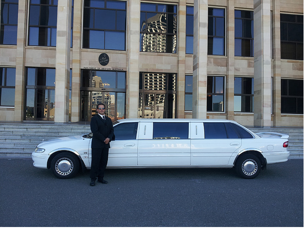 A Chauffeur Standing Beside Aesthetic White Limousine