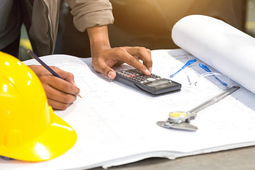 Engineer working for architectural project. calculation on drawing