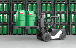 A forklift is lifting oil barrels made in Kuwait in a warehouse